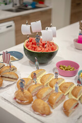 Many sandwiches and watermelon decorated for pirates on a birthday party