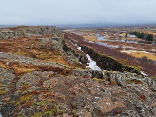 Natural hills with rock formations creating mountain wall in icelandic thingvellir national park, majestic highland cliffs made of stone. Spectacular Iceland wilderness in nordic rocky valley.