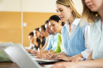 Side view of a group of adult students in university classroom
