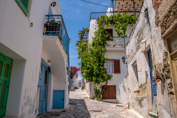 Fototapeta na wymiar European streets-Tinos Island Greece, scenes of narrow cobblestone streets, restaurant patios, and whitewashed buildings