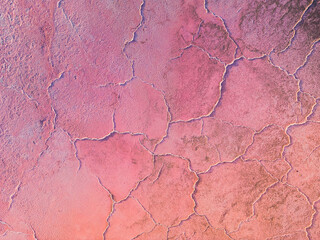 A close-up of a cracked pink salt lake at sunset creating abstract patterns. Salt production plants evaporated a brine pond in a salt lake. Salin de Giraud saltworks in Camargue, Provence, France