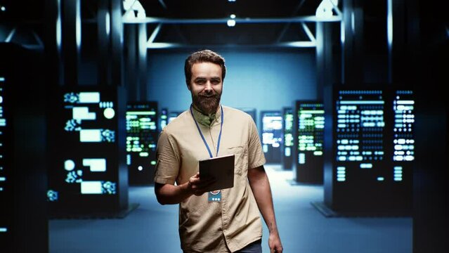 Engineer in high tech facility delivering immense computing power, capable of processing and storing vast amounts of data. Technician walking between server racks rows controlling network resources
