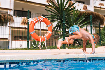 little boy swims in the pool in swimming goggles