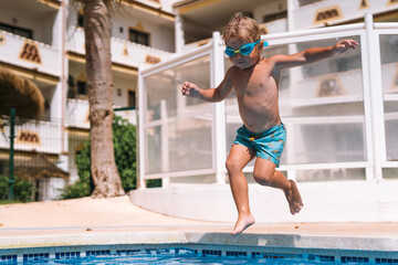 Naklejka premium little boy swims in the pool in swimming goggles