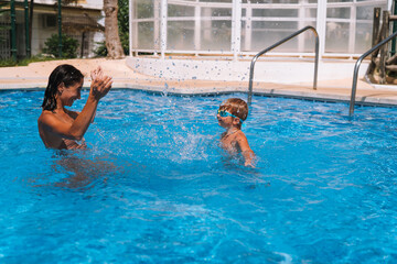 Naklejka premium mom teaches her son to swim in the pool