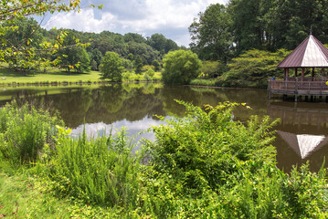 Wooden gazebo in the park near the lake on a summer day.