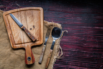 Wooden Cutting board, knife and burlap. Table dark background. top view. copyspace.