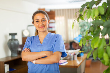 Fototapeta premium Woman doctor wear white medical uniform and stethoscope look at camera posing in private clinic