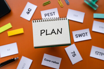 There is notebook with the word PLAN. It is as an eye-catching image.