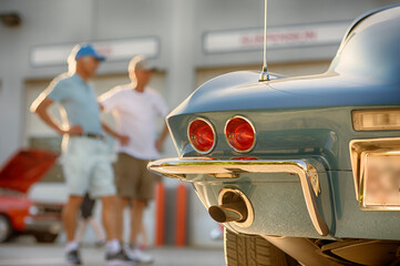 People gather to view classic muscle cars at vintage automotive exhibition. 