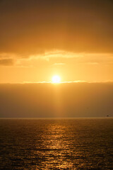 Vertical shot capturing the serene beauty of a golden orange sunset over the sea in Viña del Mar, creating a captivating and tranquil ambiance.