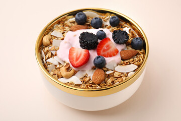 Tasty granola, yogurt and fresh berries in bowl on beige background, closeup. Healthy breakfast