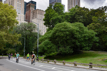 Cyclists, joggers, families and pets circulating on a summer morning in Central Park, New York....