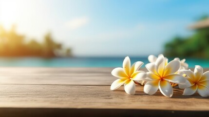 Fototapeta na wymiar Frangipani flower on wooden table. Frangipani flowers on a summer beach background