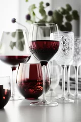 Fotobehang Variety of red wine glasses filled and empty on a white countertop in the kitchen, generative AI © fahrwasser