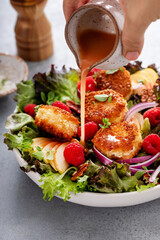 Fried goat cheese salad with apples and raspberries and vinaigrette dressing