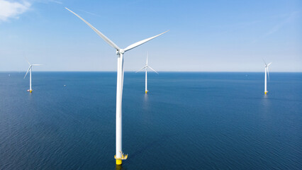 Windmill park with clouds and a blue sky, wind mill turbines in the ocean aerial view of a wind farm in the Nehterlands production clean energy