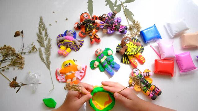 Child modeling from plasticine and clay, using nature materials,  sculpting, creating fairy tale with elves, angels, fairies. Imagination, inspiration, sensory perception, development with child