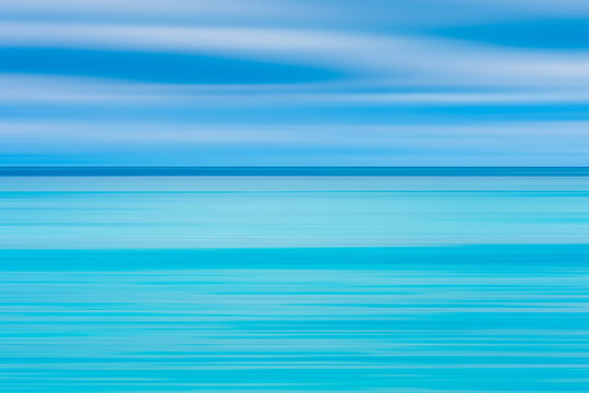 Abstract seascape with panoramic motion combined with long exposure. The image shows the different shades of blue and turquoise that make up the sea and sky soft pastel colors in a retro style.