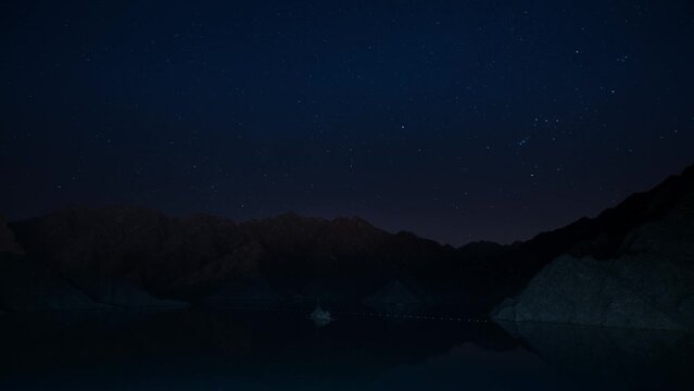 Captivating UAE's Hatta Dam night timelapse stock footage. Tranquil waters mirror open sky as day surrenders to velvety night, celestial beauty unfolds.