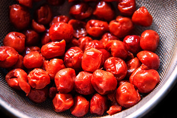 Fresh cherries are drilled in a colander