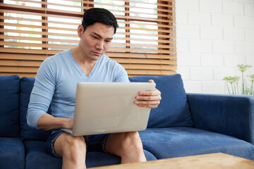 young handsome man using laptop computer for work at home