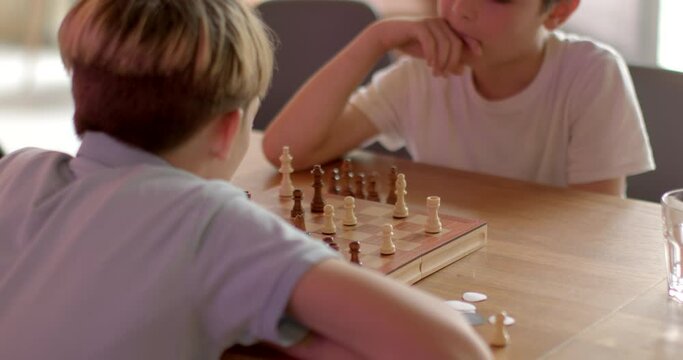 Two children playing chess in cafe, friendly interaction. Kids mentally stimulating indoor activity. Chess is brain exercise appeals to young minds seeking mental challenges beyond traditional games.