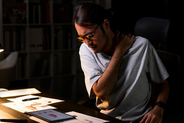 Asian man graphic designer working on computer drawing sketches logo design. Young Asian businessman looking serious and stressed while using laptop to work from home.