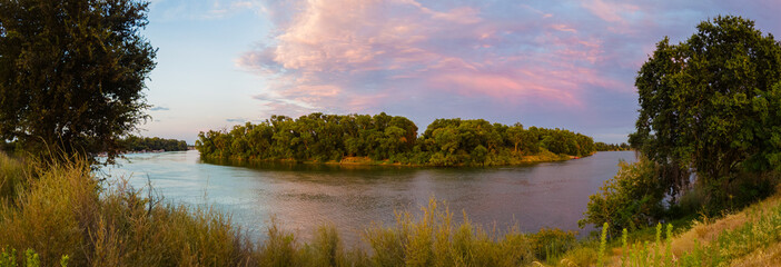 Panoramic landscape view of Sacramento river near pocket area at sunset
