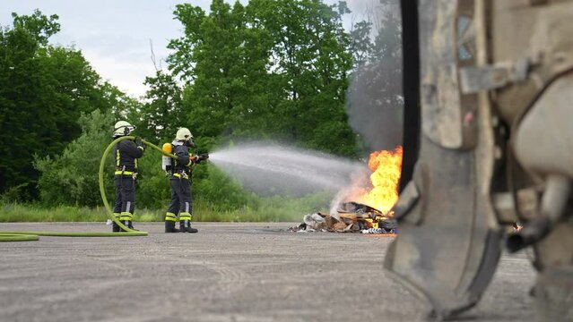 Firefighters fight the fire flame to control fire not to spreading out. Firefighter industrial and public safety concept. Traffic or car accident rescue and help action. 