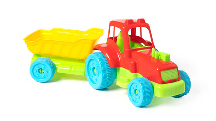 Toy tractor with a trailer isolated on white background.