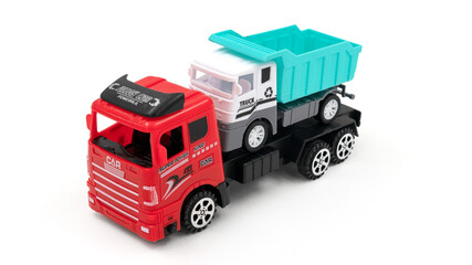 Toy truck with trailer transports dumper on white background.