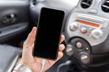 Young man using smart phone mobile phone in car. Close up view. Close up man hand holding charge the battery mobile smart phone in car.