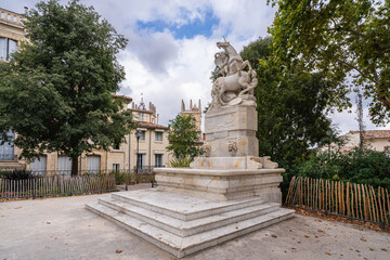 Obraz premium Cityscape view of ancient fountain of the unicorns on famous Canourgue square with St Peter cathedral in background in Montpellier historic city center, France