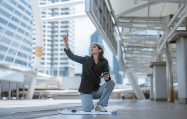 Expert female architect reviews Skytrain site, cross referencing blueprint for project approval.