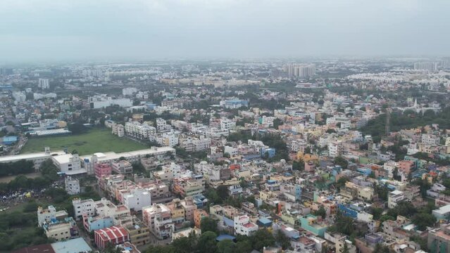 Residential homes, apartments, vacant lands, and parks can be seen in an aerial video of an South Indian city.