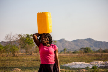 Girl carrying gallons of Water on her heads in a water-scarce region