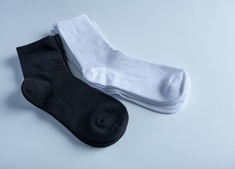 White and black socks on a white background. Flat lay, top view.