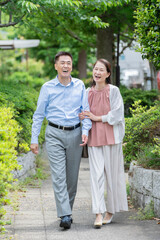 公園を散歩するシニア夫婦