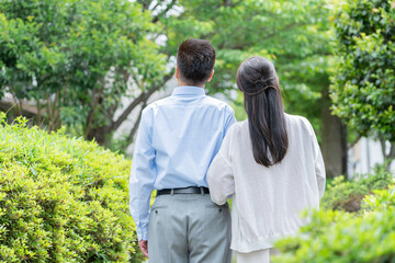 公園を散歩するシニア夫婦