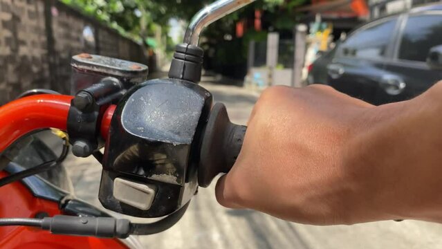 Close up male driver hand on throttle handle motorcycle on road daytime urban city. Transportation concept