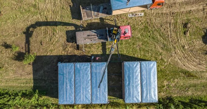 aerial timelapse of workers installing modular containers with crane manipulator