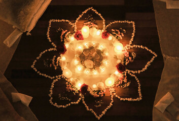 Beautiful athenic flower mandala on the floor, burning candles at women's circle event