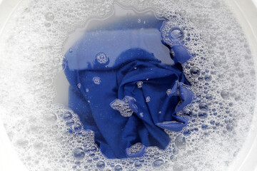 T-shirt soak in powder detergent water dissolution, washing  cloth. Laundry concept