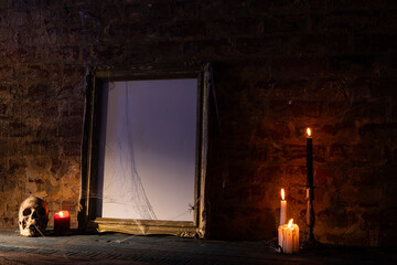 Black frame with copy space, skull, candles and smoke on brick wall background