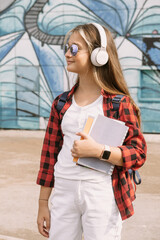 happy teen girl student in headphones streetstyle portrait