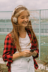 happy teen girl in headphones streetstyle portrait