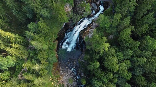 Bird's eye view of impressive Gollinger Waterfall surrounded by trees, aerial