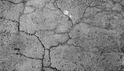 Black and white cement ground background and pattern. It is cracked of concrete street road and very fractious. The damage is caused by the impact and vibration of the ground and long-time use