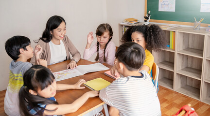 Group of pupil boy girl group study with teacher in classroom at elementary school. Student in primary school story telling. Children  classroom. Education knowledge, success teamwork concept banner
